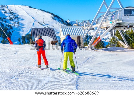 People skiing and snowboarding on a slope at ski resort, Ax-les-Thermes, France