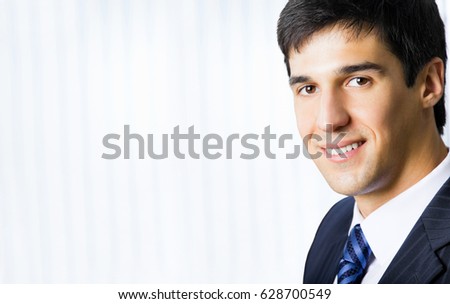 Portrait happy smiling successful businessman at office. Blank copyspace area for slogan, advertisiment or text. Success in business concept.
