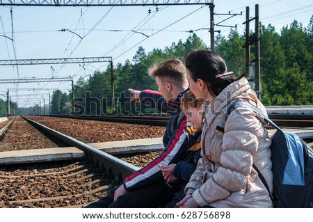 family mother and two sons, the rest sit on the railroad tracks. blurred background