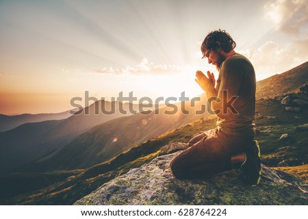 Man praying alone at sunset mountains Travel Lifestyle spiritual relaxation emotional concept vacations outdoor harmony with nature landscape