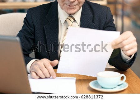 man looking at documents in cafe