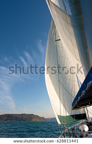 Coastal cruising sailing yacht under full sail at sea heading to Broken Bay with a vivid blue sky backdrop.
New South Wales, Australia.

