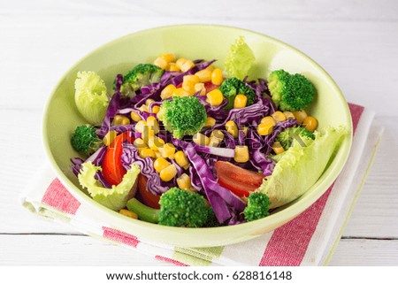 Fresh vegetable salad on white wooden table. Healthy vegetarian food. Selective focus.