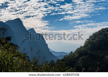 Amazing picture of green mountain landscape with blue sky and white clouds under sunlight