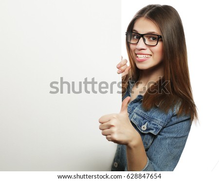 Gorgeous woman wearing glasses pointing at a board while standin