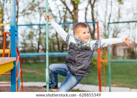 Little boy play on playground with white blur park background
