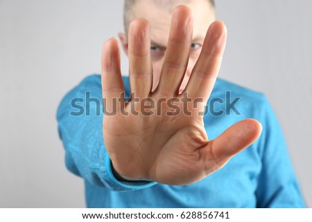 man doing stop gesture with the right hand
