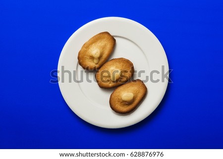 three pie(cookie) with cheese on the dish, blue background.