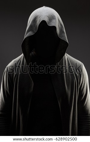 mysterious man in the hood with hidden face over dark grey background