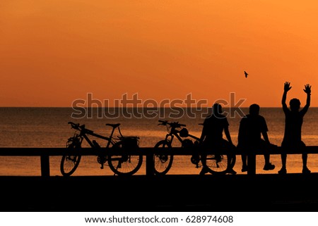 Silhouette man and bike relaxing with sunrise over the beach