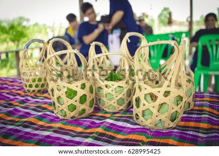 Rice in a wooden basket on blurry background.