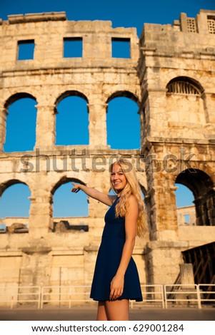 beautiful young woman tourist taking photos of roman arena in Pula croatia