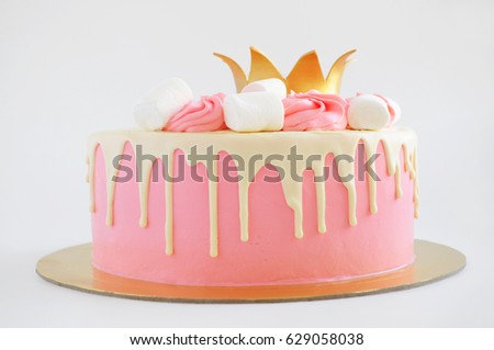 Cake for little girl with pink cream, white chocolate, decorated with marshmallow and gold crown. Picture for a menu or a confectionery catalog.