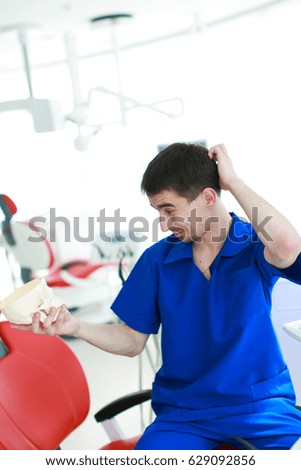 Male dentist in a dental clinic in the workplace in blue clothes