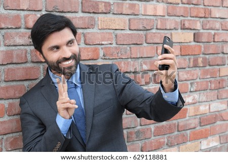 Young businessman taking a selfie with his smartphone