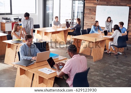 Young adult colleagues working in busy office, elevated view Royalty-Free Stock Photo #629123930