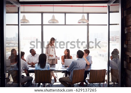 Woman standing at a meeting in a business boardroom