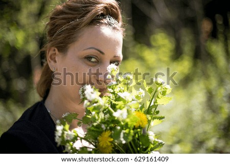 Portrait of young woman smelling bouquet of flowers