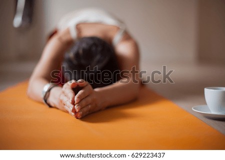 Young slim blond woman in yoga class making asana exercises. Healthy lifestyle in fitness club. Stretching. Selective focus on fingers