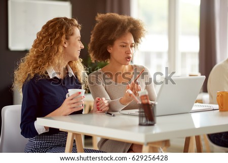 Two young women working on the laptop Royalty-Free Stock Photo #629256428