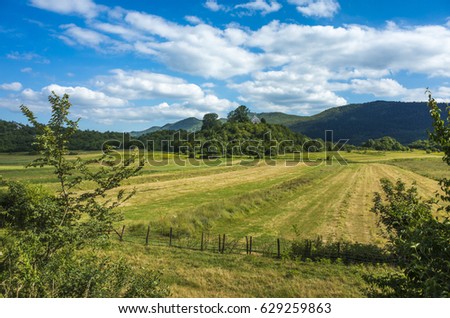 Kosinj Croatia. Beautiful nature and landscape photo. Lovely outdoors summer day. Green grass fields and blue sky. Nice calm happy image.