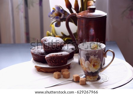 A cup of coffee and freshly baked chocolate muffins
