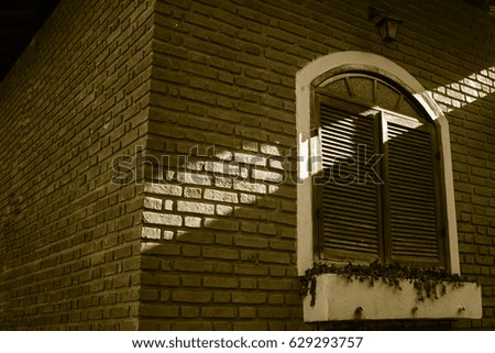 Wooden window in brick house with sunbeam