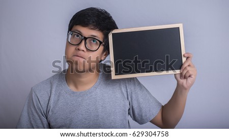 asian man hold black board on gray background for advertising