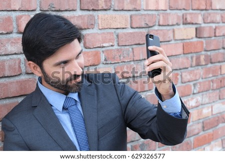 Businessman taking selfie picture with mobile phone