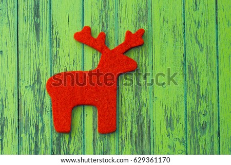 Red reindeer placed on the wooden background.