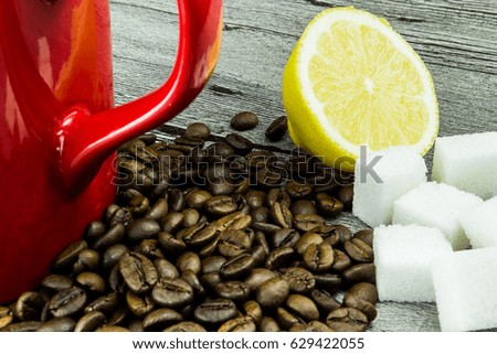 coffee grains with cup, lemon and sugar on grunge wooden background