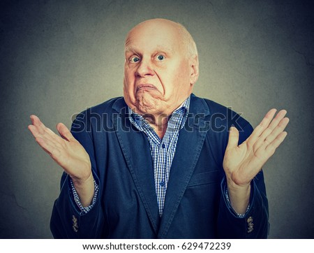 Senior confused man is shrugging his shoulders  Royalty-Free Stock Photo #629472239