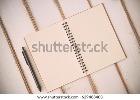 Creative flat lay mockup design of workspace desk with blank notebook and black pen on the wooden background with copy space. Business Concept