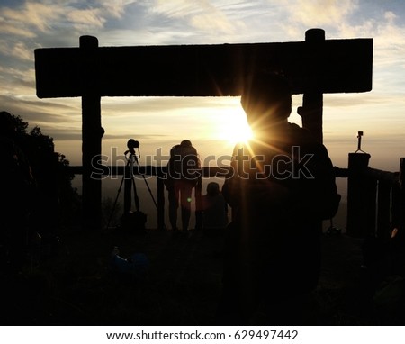 Silhouette of the tourist Enjoy photography on Beautiful high mountains with foggy and sunrise background