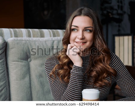 Beautiful young woman sitting in italian style cafe with cup of latte, creative toning