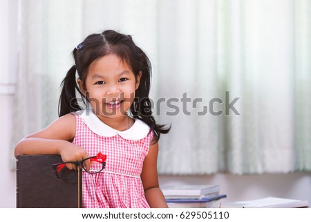 Portrait of happy asian little girl with book 