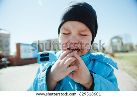 Little boy crying on the street.
