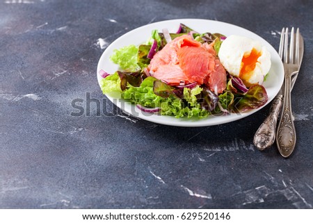 Healthy food - vegetables and salmon salad on a dark background. Selective focus. Copy space