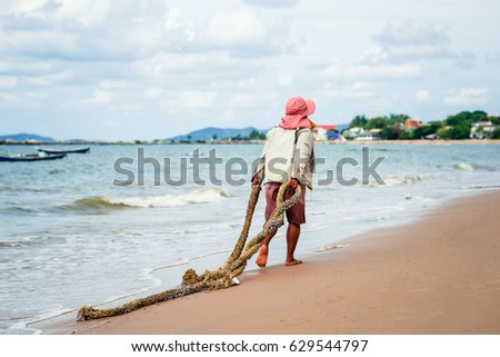 women keep rope old on beach in morning at thailand