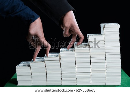 Two Hand of male used finger are competing walk step on stack of dollars growing in business, concept in growth, finance, competition and success