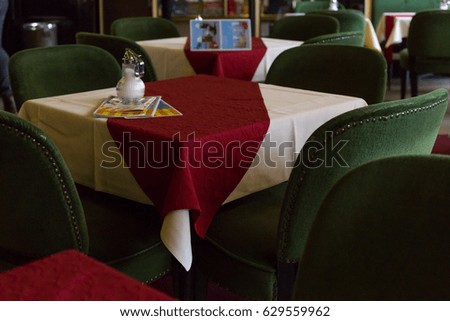 red green table cover and a warm light with comfortable seats make cafe look romantic and warm