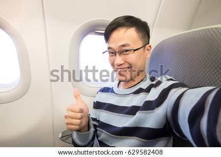 man thumb up and smile happily in the airplane