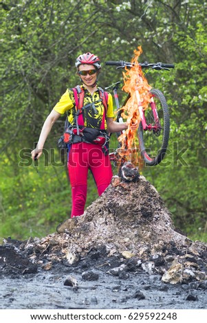 Ukraine, Prykarpattya - in the Carpathians there is an interesting phenomenon of a small mud and flaming volcano in the village of Starunia. Traveler cyclist is photographed in fire flashes