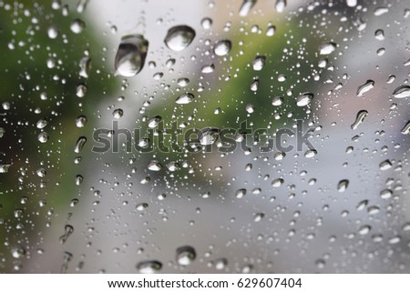 Rain drops on glass window with blur background