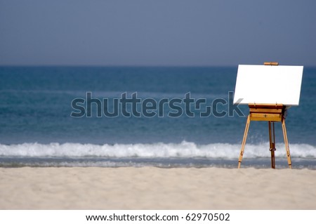 A blank white canvas rests on a traditional wooden easel on an empty tropical beach. copy space. Creativity concept.No people. Copy space