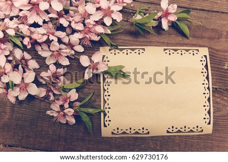 writing retro card whis peach blossoms on a wooden vintage table