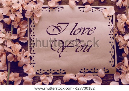 Note, postcard, writing retro peach blossoms on a wooden vintage table, peach flower on the table background. Spring pink flowers.
