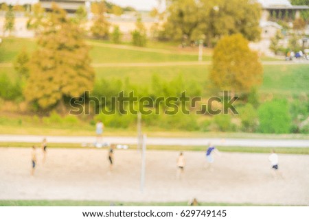 Blurred image group of Caucasian young people playing outdoor volleyball in summer at urban park in downtown Houston, Texas, US. Volleyball blur background. Healthy lifestyle, sport teamwork concept.