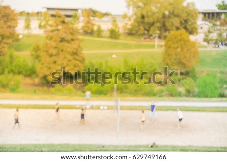 Blurred image group of Caucasian young people playing outdoor volleyball in summer at urban park in downtown Houston, Texas, US. Volleyball blur background. Healthy lifestyle, sport teamwork concept.
