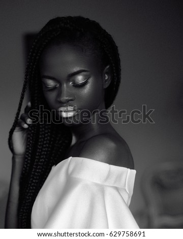 black and white photo of african woman.portrait. Girl in white dress with white makeup